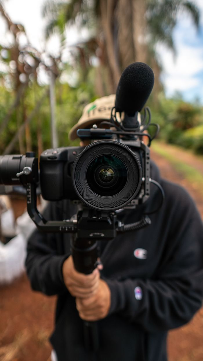 Mastering the First Impression: Your intriguing post title goes here A videographer holding a professional camera and microphone outdoors.